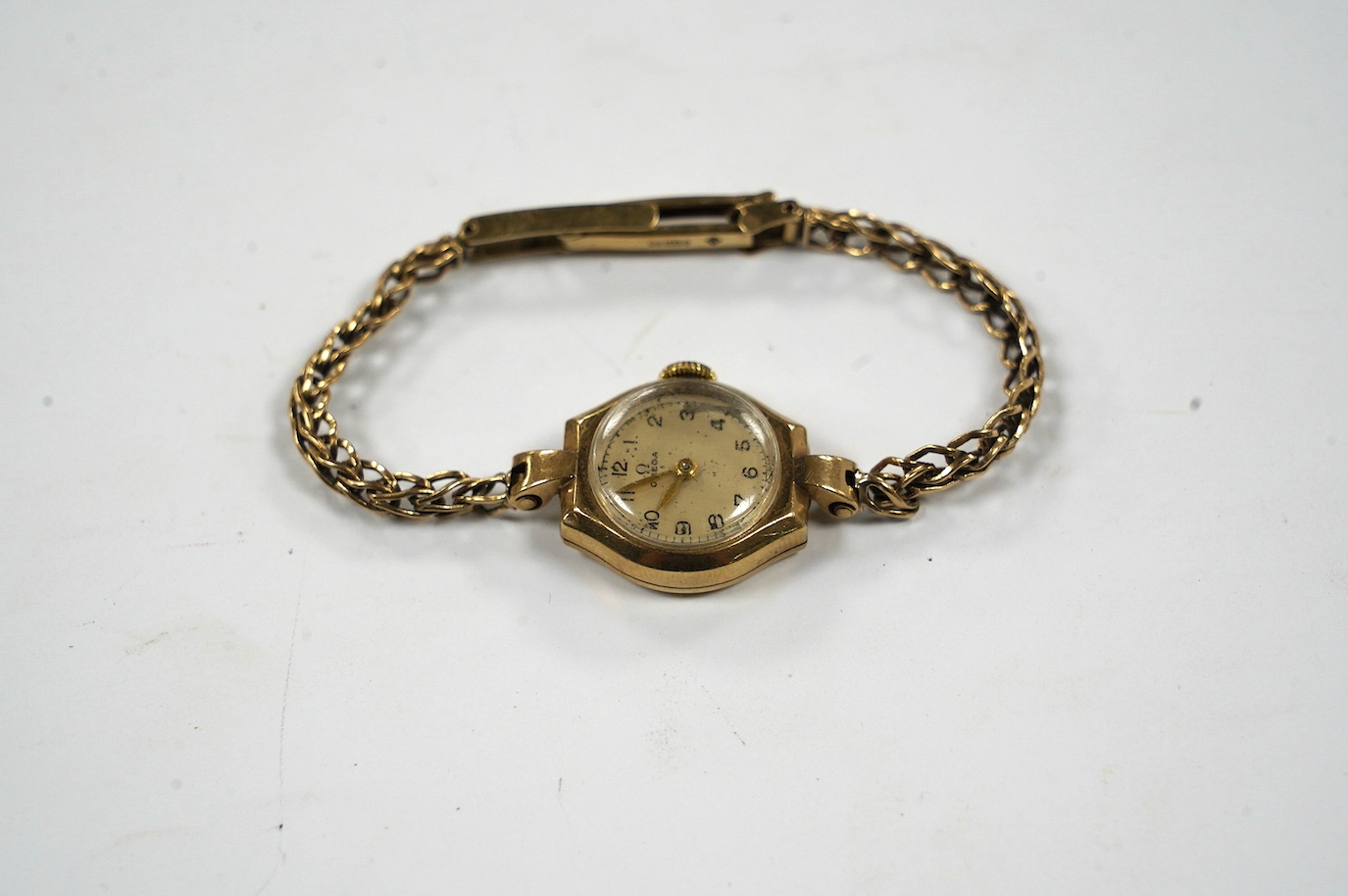 A lady's 9ct gold Omega manual wind wrist watch, on an associated 9ct bracelet, gross weight 12.8 grams. Condition - poor to fair